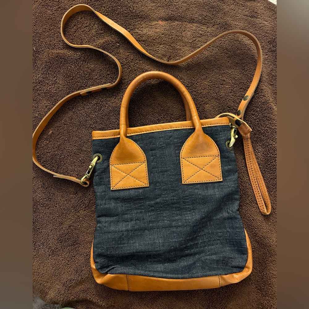 Genuine Italian leather and denim bag with two handles and a crossbody strap.